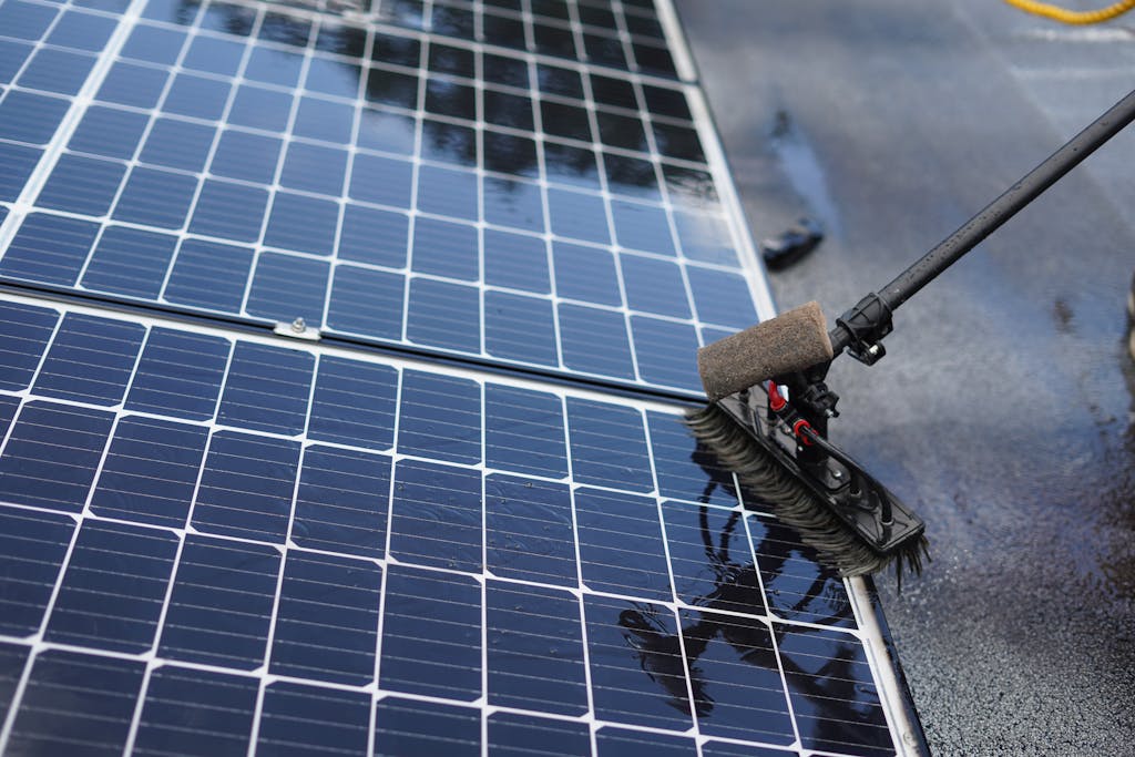 Rooftop solar panels being cleaned with a brush