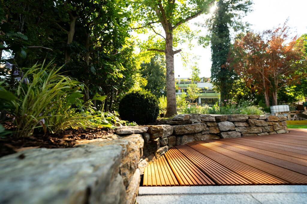 Landscaped garden beds and low stone wall beside a walkway